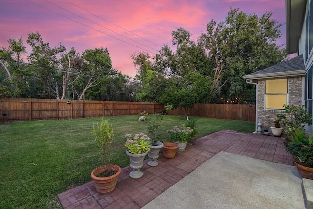 yard at dusk with a patio area