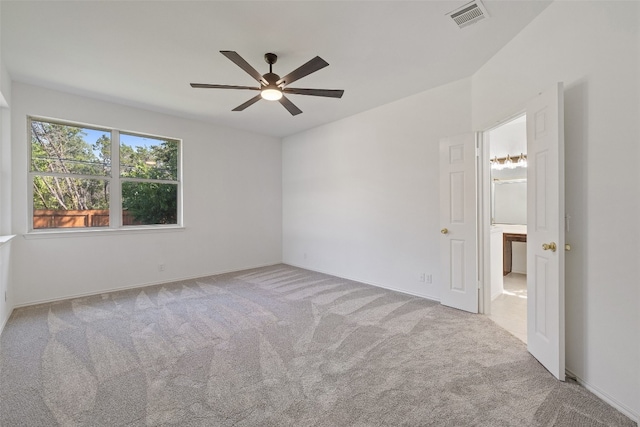 spare room with ceiling fan and light colored carpet