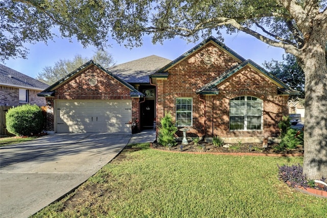 view of front of house featuring a front yard, an attached garage, brick siding, and driveway