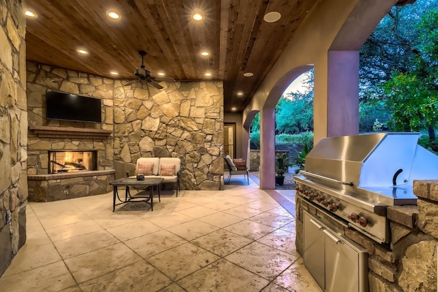 view of patio with an outdoor stone fireplace, area for grilling, and a grill