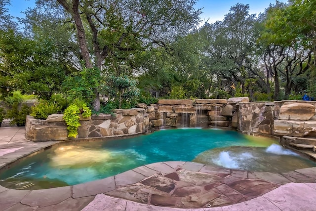 view of swimming pool featuring a hot tub and pool water feature