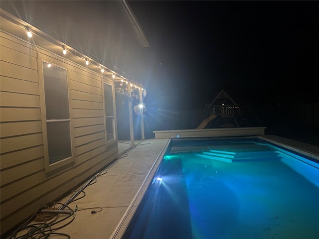 view of pool at twilight