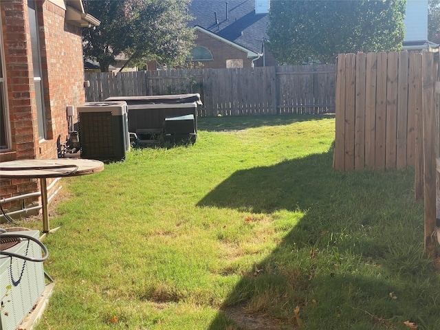 view of yard featuring a hot tub and central AC