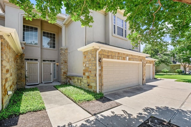 view of front of property with stone siding, driveway, and stucco siding