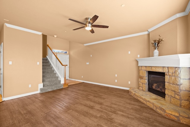 unfurnished living room with hardwood / wood-style flooring, ceiling fan, crown molding, and a fireplace