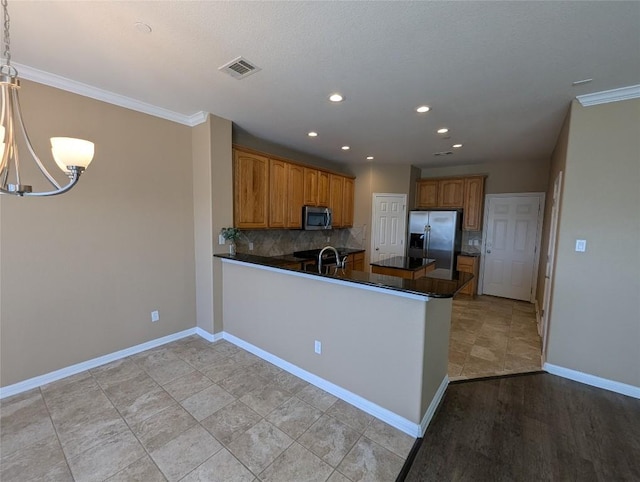 kitchen with brown cabinets, stainless steel appliances, visible vents, a sink, and a peninsula