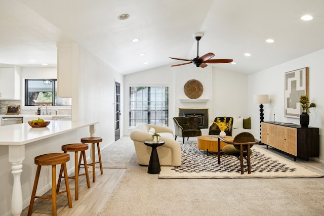 living room with a fireplace, vaulted ceiling, and a wealth of natural light