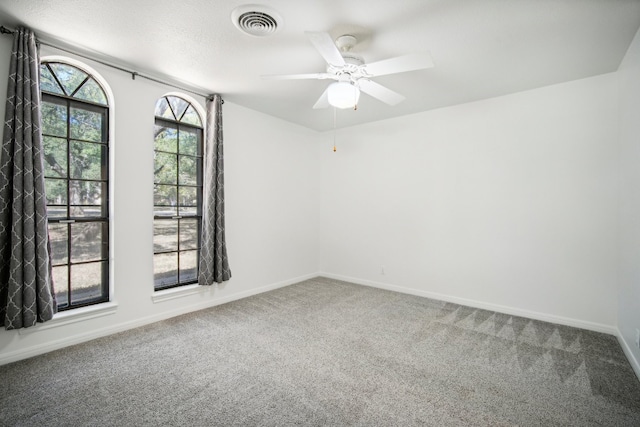 carpeted spare room with ceiling fan