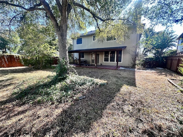 rear view of property featuring a lawn