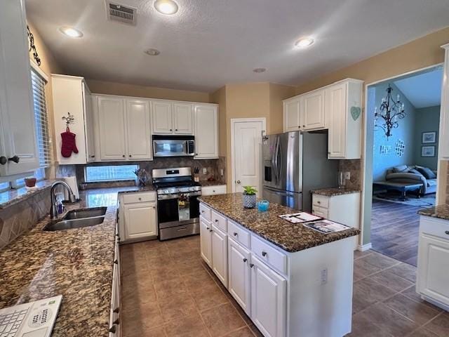 kitchen featuring sink, white cabinets, a center island, and appliances with stainless steel finishes