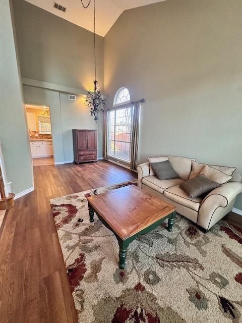 living room with hardwood / wood-style flooring and high vaulted ceiling