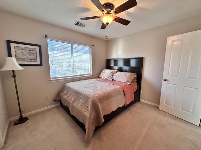 bedroom with ceiling fan and light carpet