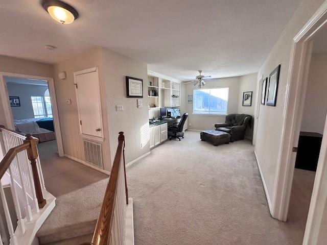 living room with ceiling fan, light carpet, and a healthy amount of sunlight