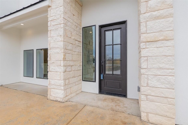 doorway to property featuring stucco siding
