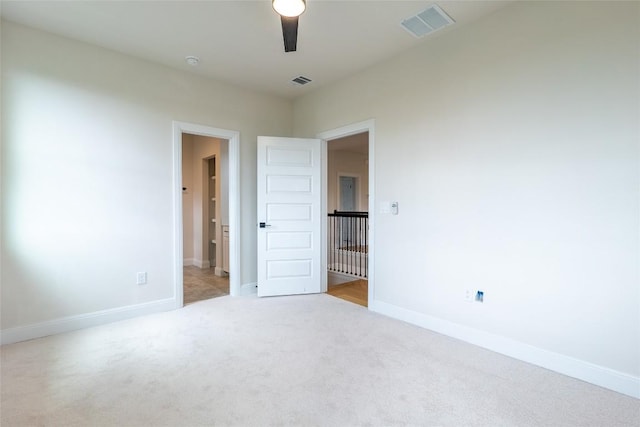 spare room featuring ceiling fan and light carpet