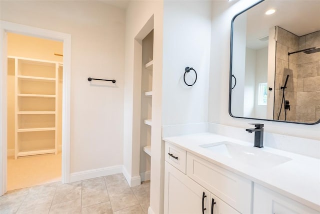 bathroom featuring tile patterned floors, vanity, and tiled shower