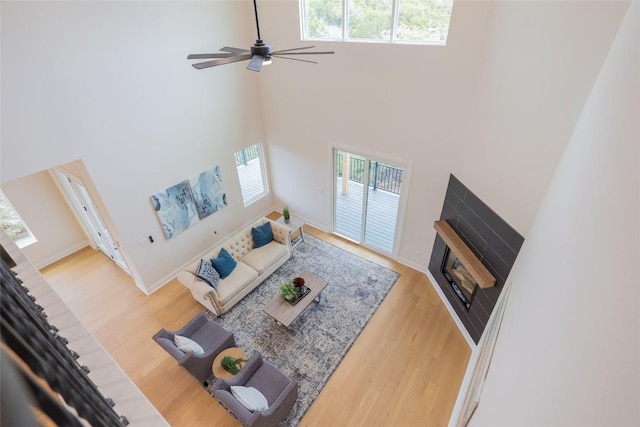 living room with a towering ceiling, a healthy amount of sunlight, and wood-type flooring