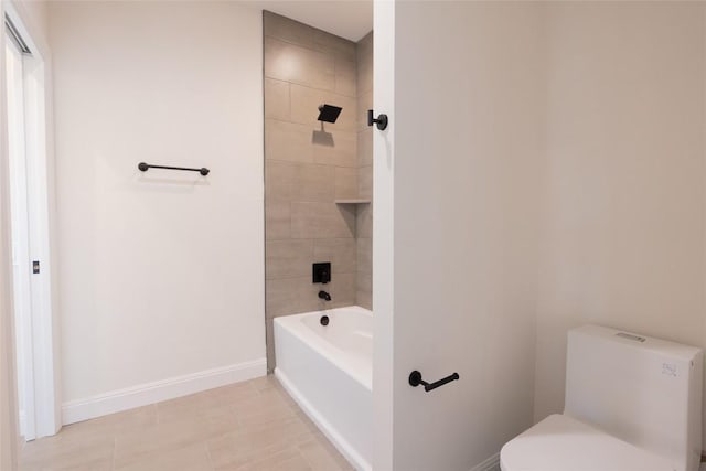 bathroom with tile patterned flooring, toilet, and tiled shower / bath