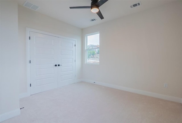 unfurnished bedroom with a closet, ceiling fan, and light colored carpet