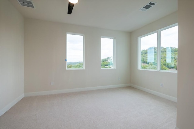 carpeted empty room featuring a wealth of natural light and ceiling fan