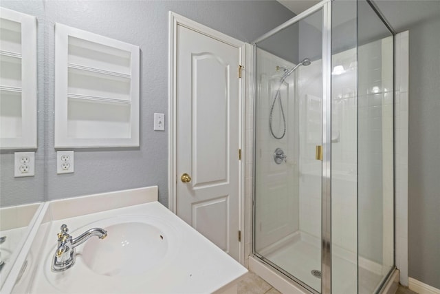 bathroom featuring walk in shower, tile patterned flooring, and sink