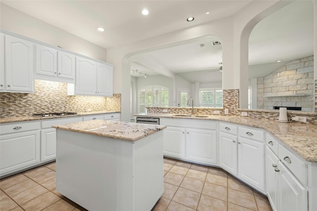 kitchen with kitchen peninsula, sink, and white cabinets