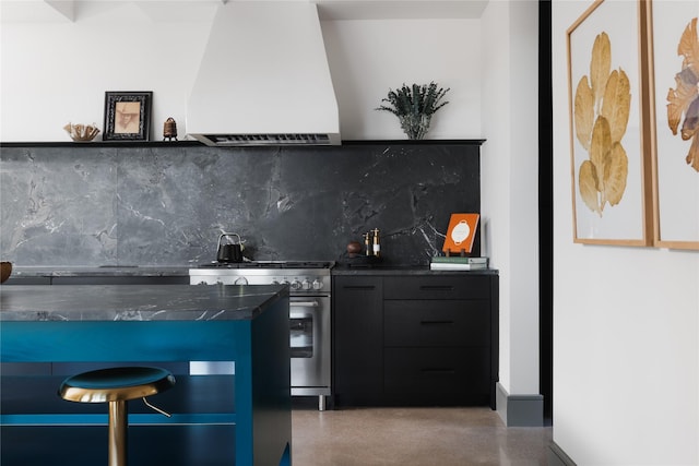 kitchen with decorative backsplash, wall chimney range hood, and stainless steel stove