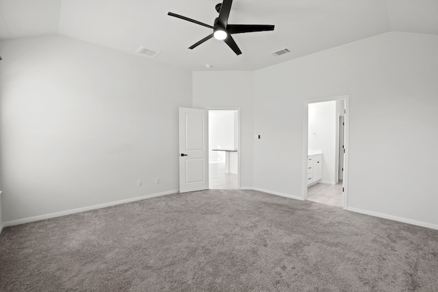 unfurnished bedroom featuring connected bathroom, ceiling fan, light carpet, and vaulted ceiling