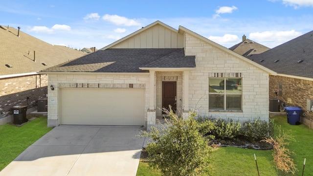 view of front of house with a front yard, a garage, and cooling unit