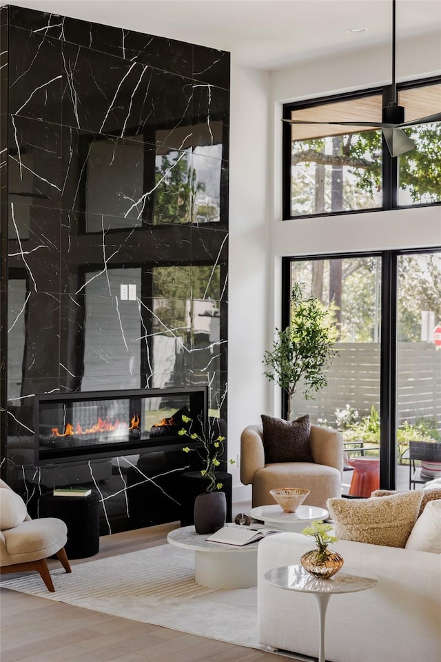 living room with a high end fireplace and hardwood / wood-style floors