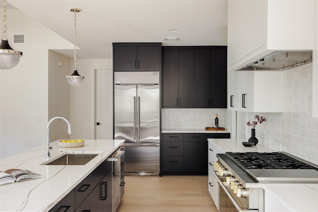 kitchen featuring decorative light fixtures, sink, decorative backsplash, and high end appliances