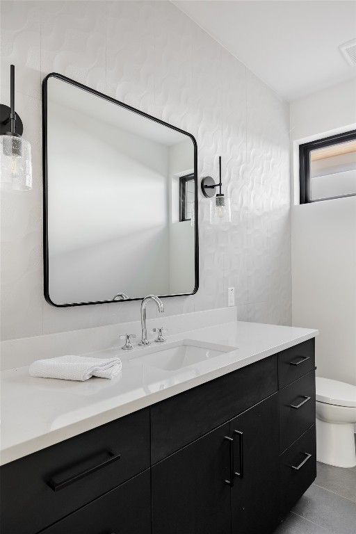 bathroom featuring toilet, tile patterned floors, and vanity