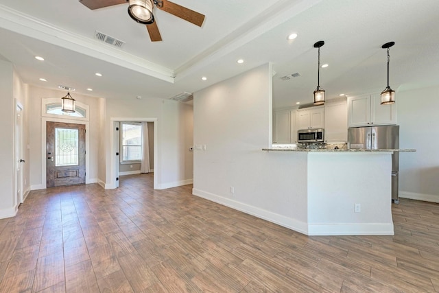 unfurnished living room featuring ceiling fan and light hardwood / wood-style floors