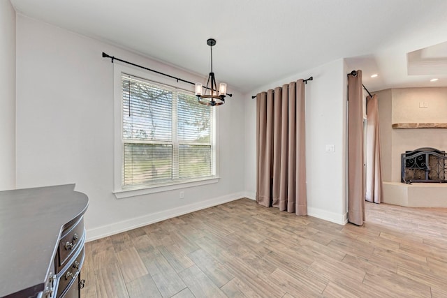 unfurnished dining area with light hardwood / wood-style flooring and a chandelier