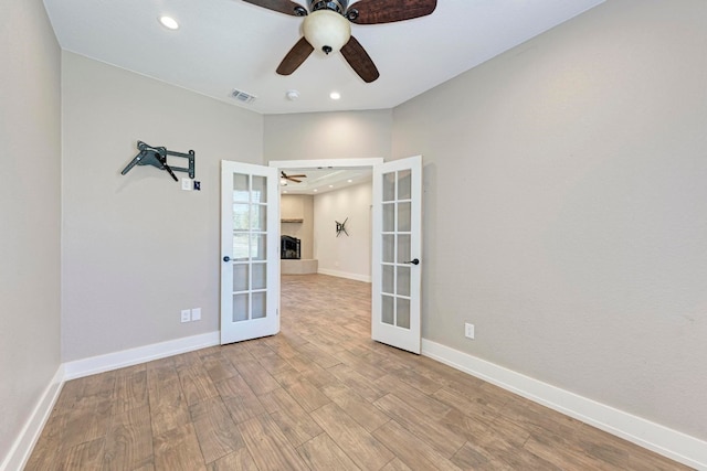 spare room with ceiling fan, light hardwood / wood-style floors, and french doors