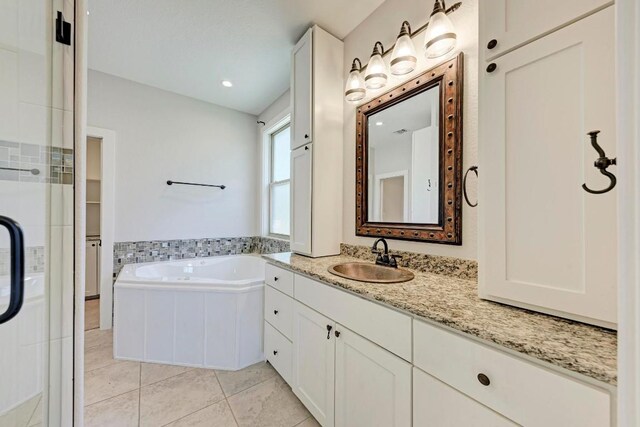 bathroom featuring vanity, a bathtub, and tile patterned flooring