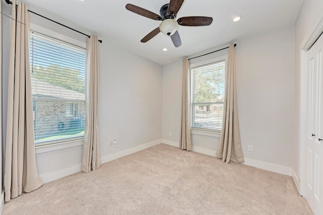 unfurnished bedroom with multiple windows, light carpet, and ceiling fan