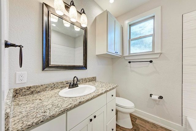 bathroom featuring wood-type flooring, vanity, and toilet