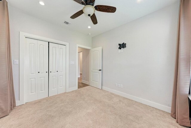 unfurnished bedroom featuring a closet, ceiling fan, and light colored carpet