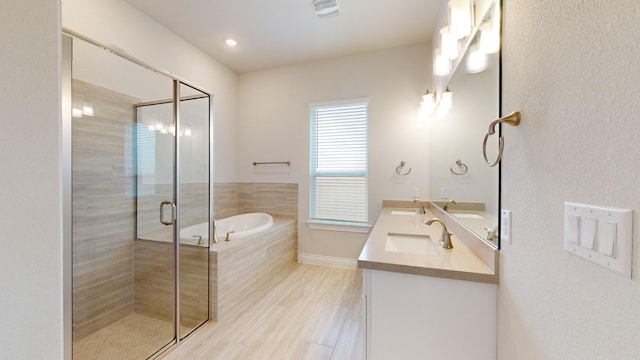 bathroom featuring hardwood / wood-style floors, vanity, and plus walk in shower