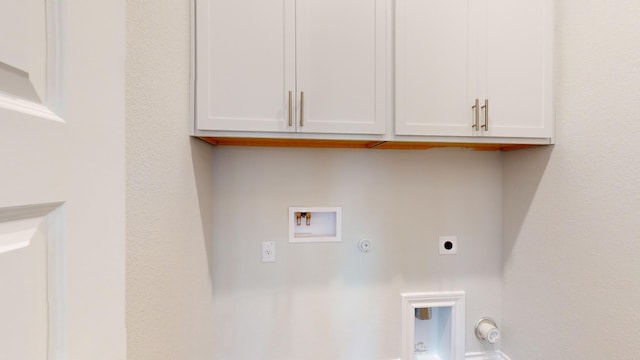 clothes washing area featuring gas dryer hookup, cabinets, washer hookup, and hookup for an electric dryer