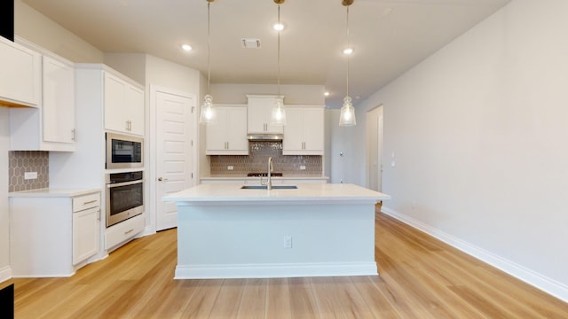 kitchen with pendant lighting, light wood-type flooring, white cabinetry, and stainless steel oven