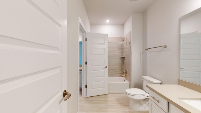 full bathroom with vanity, toilet, wood-type flooring, and tiled shower / bath