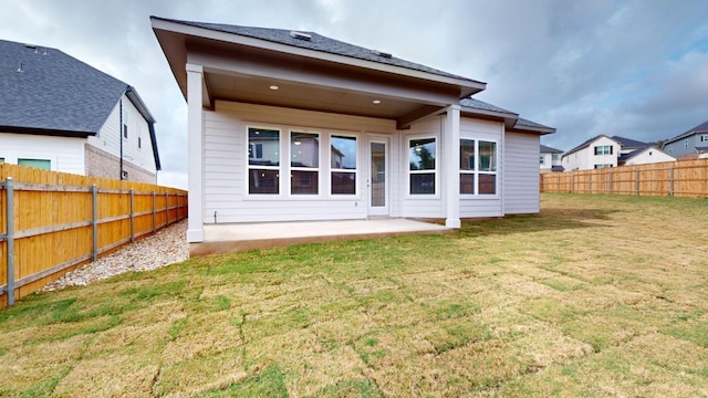 rear view of house with a yard and a patio