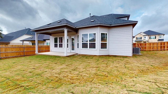 rear view of property with a yard, a patio, and central air condition unit