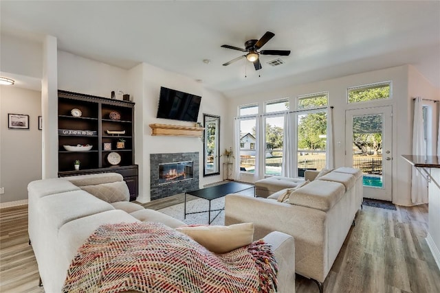 3110 Point Cv, Lago Vista, TX 78645 - living area featuring a glass covered fireplace, wood finished floors, and ceiling fan