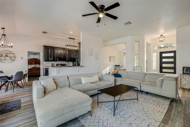 3110 Point Cv, Lago Vista, TX 78645 - living room featuring a chandelier, light wood finished floors, and a ceiling fan