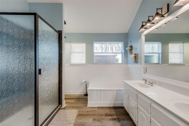 3110 Point Cv, Lago Vista, TX 78645 - full bath with wood finished floors, a stall shower, a bath, double vanity, and a wainscoted wall