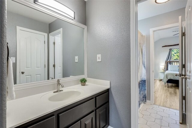 3110 Point Cv, Lago Vista, TX 78645 - ensuite bathroom with a textured wall, vanity, and tile patterned flooring