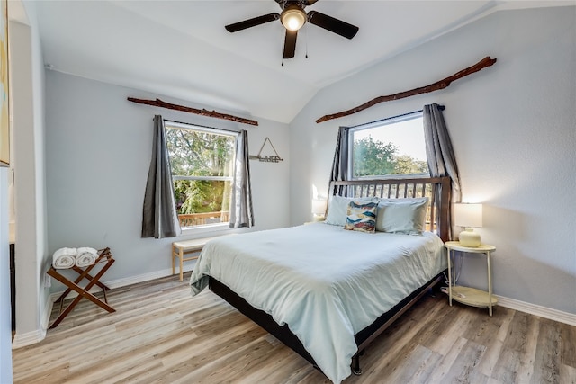 bedroom with vaulted ceiling, multiple windows, hardwood / wood-style floors, and ceiling fan